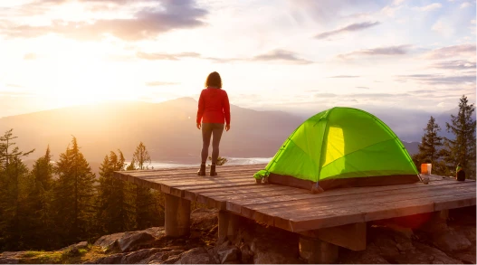 a woman standing on a rock looking out over a valley